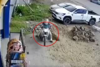 WATCH POTHOLE SWALLOWS MAN AND HIS BIKE IN PARKING SPACE