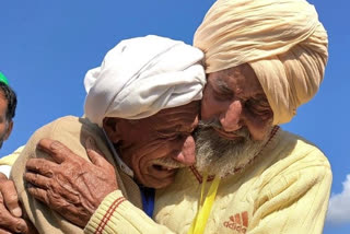 Indian Sikh labourer Sika Khan (R) tearfully embraces his elder brother Sadiq Khan from Pakistan near the border at the Kartarpur corridor