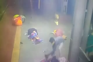 Person picking up a sleeping child at Kalyan railway station