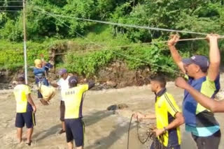 SDRF helps a pregnant woman in crossing an over flowing drain with the help of rope in Tehri