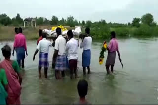 இறந்தவரின் உடலை ஆற்றில் இறங்கி தூக்கிச் செல்லும் அவலம்