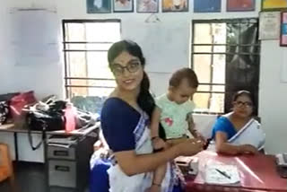 teacher in majuli with baby in her lap