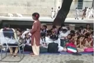 जमीन पर बैठकर पढ़ते छात्र