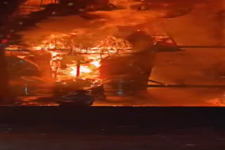 man sitting under burning effigy of ravana