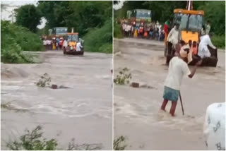 ജെസിബിയുടെ കൈകളിൽ ഇരുന്ന് യാത്ര  നദി മുറിച്ച് കടക്കാൻ സാഹസിക യാത്ര  People crossed flooded ditch sitting on JCB bucket  സാഹസിക യാത്രയുമായി ഗ്രാമീണർ  കർണാടകയിൽ കനത്ത മഴ  Karnataka Rain  ജെസിബി  നിറഞ്ഞൊഴുകുന്ന നദി മുറിച്ച് കടക്കാൻ ജെസിബി