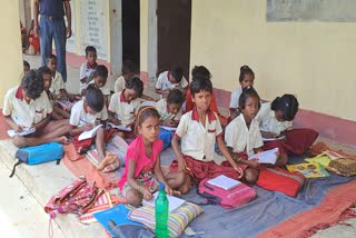 Children study sitting on ground in Olympic player village in Simdega