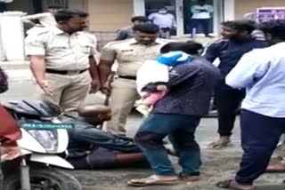 Etv BharatA rider protesting by sitting on the pothole where fell from his bike