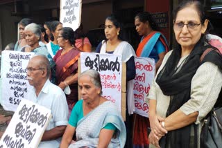 Foreclosure on Koottikkal flood land  old couple protesting  old couple protesting infront of Kerala bank  Kerala bank Foreclosure on Koottikkal flood land  കൂട്ടിക്കല്‍ പ്രളയ ഭൂമിയില്‍ ജപ്‌തി  കൂട്ടിക്കൽ  കേരളബാങ്ക്  സഹകരണ വകുപ്പ് മന്ത്രി വി എന്‍ വാസവന്‍