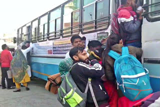 Students traveling by hanging on bus doors