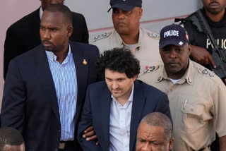 FTX founder Sam Bankman-Fried, center, is escorted out of Magistrate Court into a Corrections van, following a hearing in Nassau, Bahamas