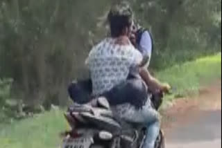 man riding on bike with woman on tank in reverse