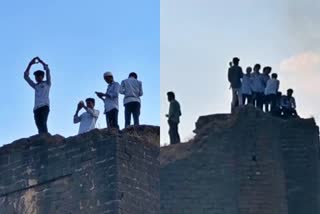 Youngsters taking selfies at the top of the fort avoiding security