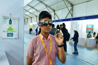 Student shows glasses made to alert visually impaired people at ISC