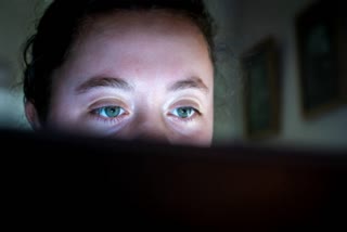 Young woman eyes watching a computer screen