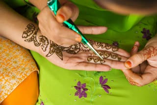 Girl drawing design using mendhi