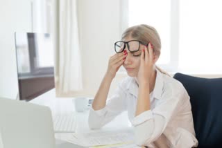 Tired businesswoman rubbing eyes in office