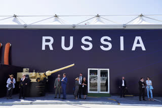 Russian salespeople stand by a tent for Russian weapons manufacturers at the International Defense Exhibition and Conference in Abu Dhabi, United Arab Emirates, Monday, Feb. 20, 2023. Just outside of Abu Dhabi's biennial arms fair in a large tent, Russia offered weapons for sale Monday ranging from Kalashnikov assault rifles to missile systems despite facing sanctions from the West over its war on Ukraine. (AP Photo/Jon Gambrell)