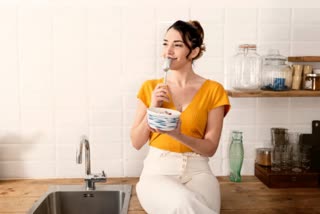 young woman having breakfast in the kitchen