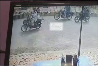 Dog tied behind a bike and dragged