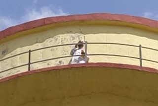 young man climbed on water tank