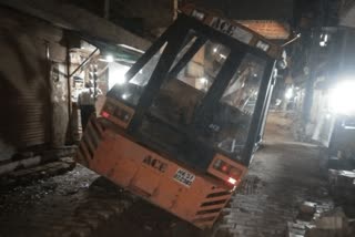 Crane stuck in dilapidated road in Sainik Enclave