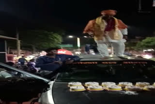 Right-wing leader Raunak Thakur standing on the roof of his car in Agra