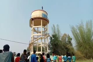 young man climbing on water tank