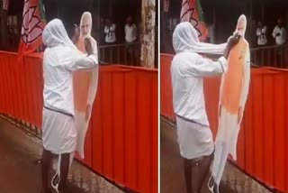 KARNATAKA MAN WIPES OFF RAINWATER FROM A CUTOUT OF PM MODI