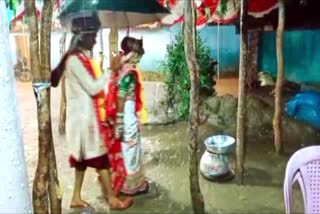 Bride and groom  Bride and groom performs wedding rituals  wedding rituals in rain  viral video  wedding rituals in heavy rain  ആശംസ മാരി  കനത്ത മഴ  മഴയത്ത് കുട ചൂടി കതിര്‍മണ്ഡപം വലംവച്ച്  കതിര്‍മണ്ഡപം വലംവച്ച് വധൂവരന്മാര്‍  വീഡിയോ വൈറല്‍  മഴ  വധു  വരന്‍