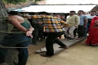 Young man tied to a tree and beaten