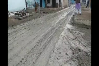 Villagers passing through broken road and mud