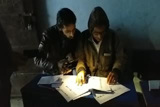 Voting being done under flashlight in pink booth in giridh