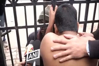 Delhi: A student of Jamia Millia Islamia University removes his shirt and sits at the gate of university  ഡൽഹി പൊലീസിനെതിരെ ഷർട്ട് അഴിച്ച് പ്രതിഷേധവുമായി വിദ്യാർഥി