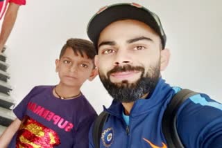 virat kohli holds a selfie