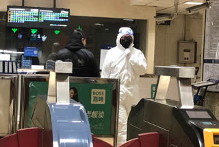 A security officer wears a hazardous materials suit at a subway station in Beijing