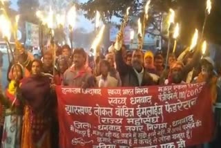 Corporation workers fired a  torch procession in Dhanbad