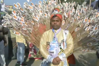 AAP supporter comes dressed as peacock  Kejriwal's swearing-in ceremony  AAP  Man dressed as peacock  കെജ്‌രിവാളിന്‍റെ സത്യപ്രതിജ്ഞ ചടങ്ങ്  ഡല്‍ഹി മുഖ്യമന്ത്രി  അരവിന്ദ് കെജ്‌രിവാള്‍