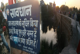 board of caution is on the bridge in delhi near shaheen bagh