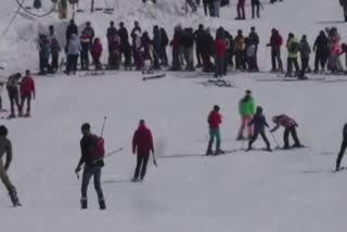 Tourists enjoy snowfall at Gulmarg