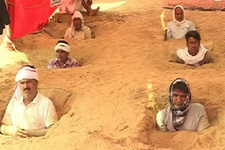 Farmers bury themselves neck-deep in ground to protest against land acquisition