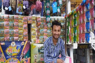 A Muslim youth decorates a color shop in Muzaffarnagar on the eve of Holi