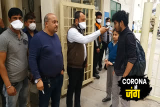 people in Mahagun Mansion Society are checking with infrared thermometer due to Corona virus fear