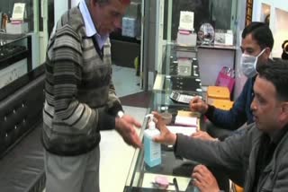 shopkeeper providing  Sanitizer to customers in mandi