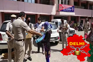 Delhi,Najafgarh police in the morning distribute milk and biscuits to needy people.