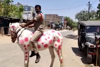 Sub Inspector rides a horse painted with images of COVID19 virus to create awareness