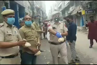 police distributed food to needy people at lal kuan in delhi