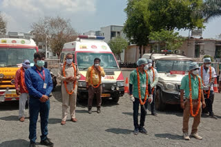 Greeting ambulance drivers with flower garlands