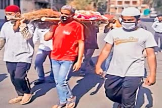 Muslim men help to carry hindu woman bier to the cemetery