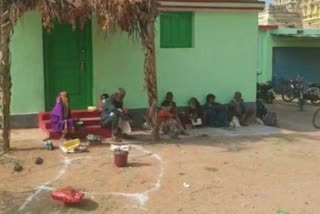 The queue of bags in front of the ration shop: people sitting in groups