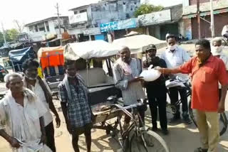 Distribution of rice to rickshaw workers at Chodavaram